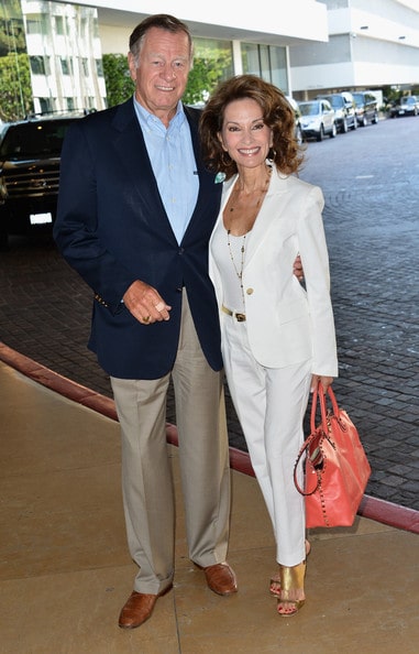Helmut Huber in a blue coat and grey pants with his wife Susan Lucci in a white formal attire.
